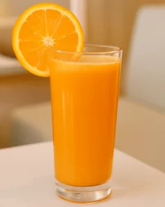 Freshly squeezed orange juice served in a tall glass with a slice of orange garnish.